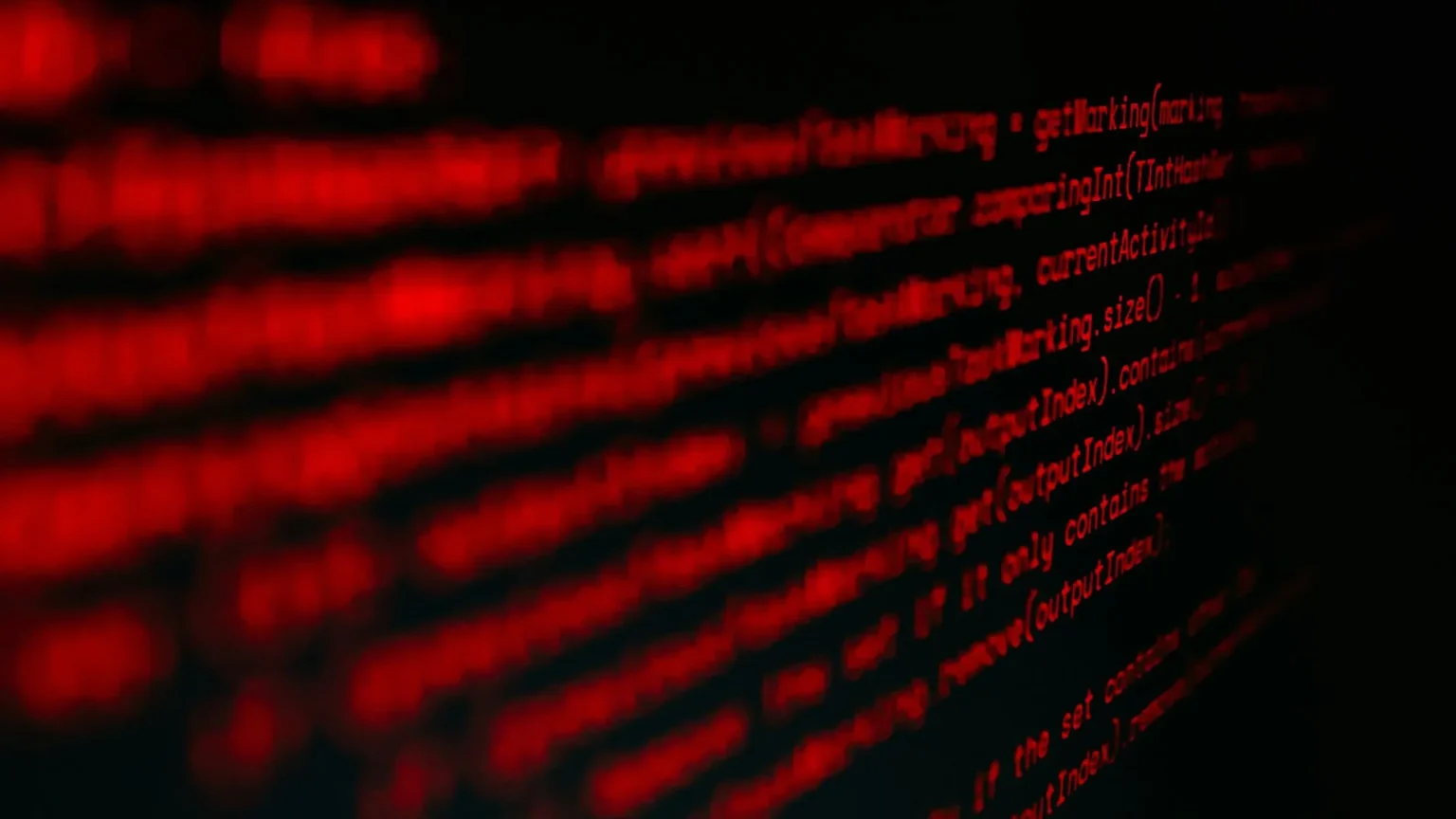 Crypto Wallet Hack Drains $7.8 Million Through a Simple Authorization Flaw Blurred red computer code glows against a black background, receding in angled lines and creating an ominous, cyberpunk atmosphere