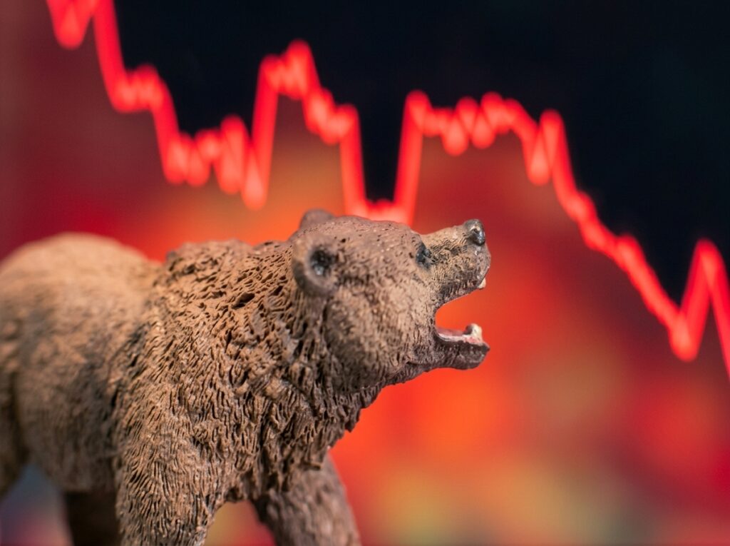 Crypto Bear Market Claims Two More as Linera and Switchboard Shut Down Roaring brown bear figurine before a blurred red stock-market crash graph