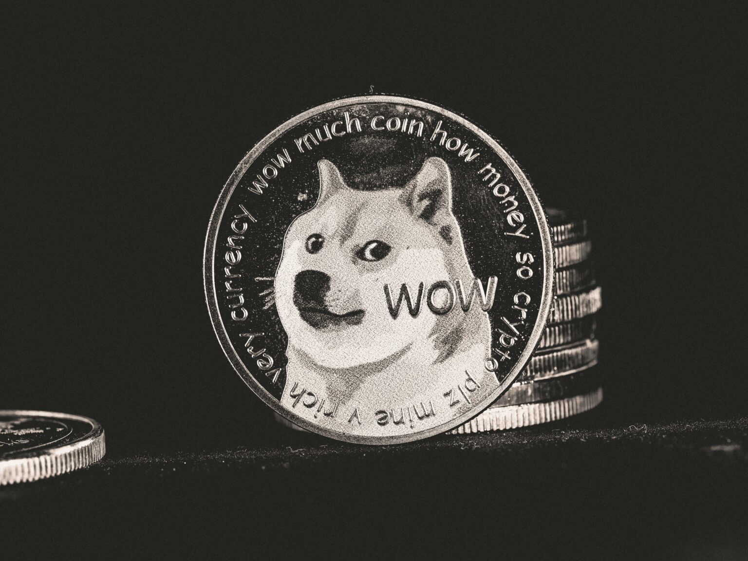 Arc Network Debut Drew Memecoin Traders First — And They Dominated Volume Close-up of a Dogecoin coin featuring the Shiba Inu “wow” text, leaning against stacked coins on a dark surface